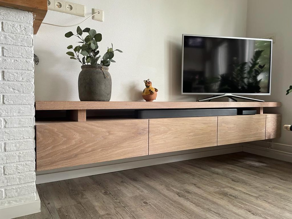 Maatwerk tv-meubel met houtafwerking en ruimte voor apparatuur